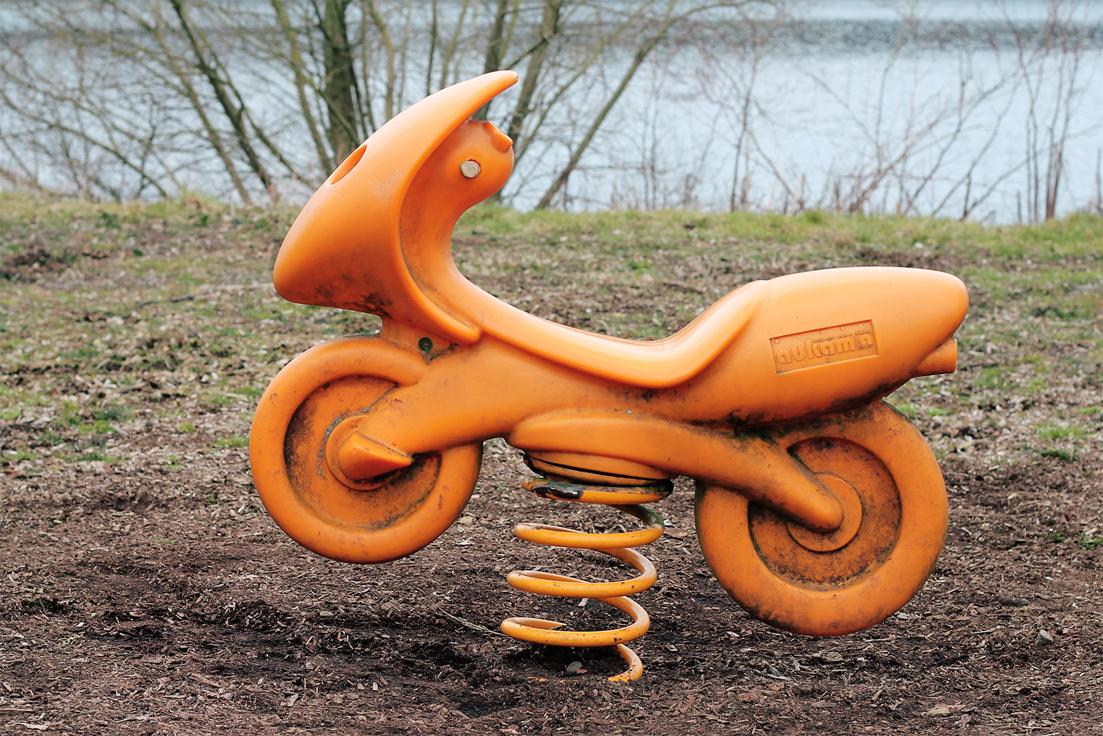 Ein Kinderspielzeug zum Draufsetzen und Wippen in Form eines orangenen Motorrads
