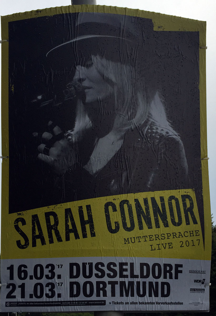 Ein Plakat, auf dem die Sängerin Sarah Connor abgebildet ist. Darunter Tourneedaten.