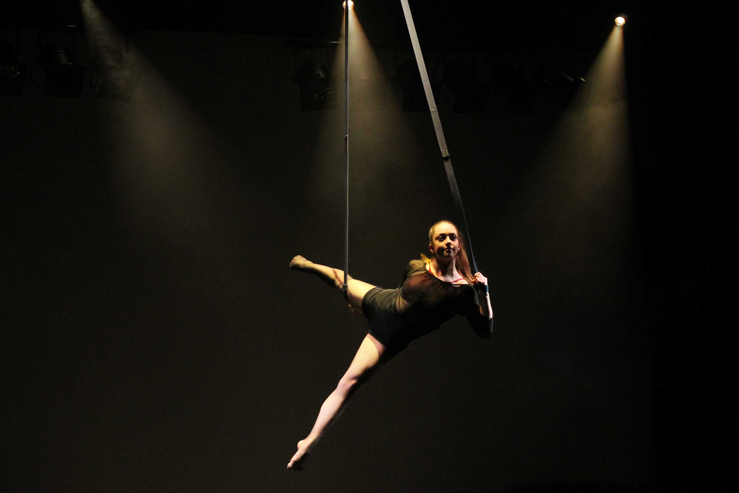 Eine Artistin hängt in Seilen in der Luft