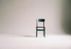 Ein grüner Stuhl vor einem weißen Hintergrund.