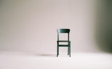 Ein grüner Stuhl vor einem weißen Hintergrund.