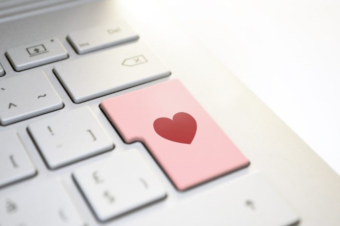 Eine Tastatur, deren Enter-Taste rosafarben ist und ein rotes Herz hat.