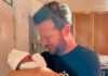 Johannes hält ein Baby auf dem Arm und lächelt selig