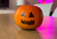 Eine Mandarine mit aufgemaltem Halloween-Gesicht