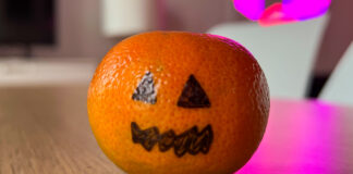 Eine Mandarine mit aufgemaltem Halloween-Gesicht