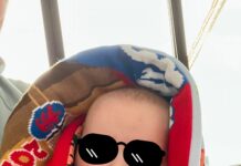 Ein kleiner Junge ist in einen Schal gewickelt. Auf seine Augen wurde eine Sonnenbrille retuschiert.