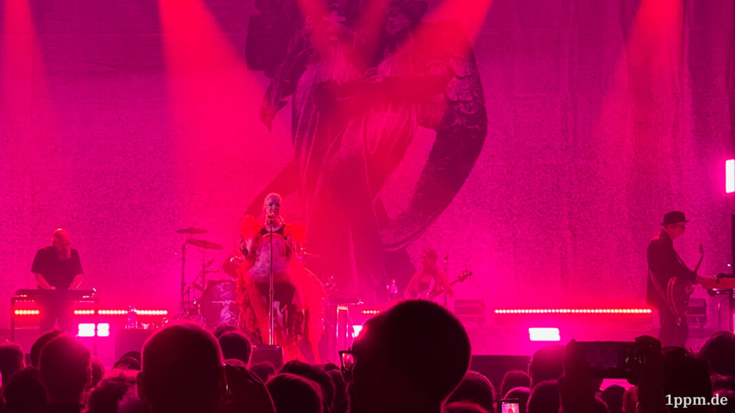 Live-Auftritt einer Band auf der Bühne mit roter Beleuchtung.