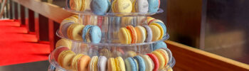Eine große Etagere mit lauter bunten Macarons, auf die jeweils klein das Gebäude der Oper aufgedruckt ist.