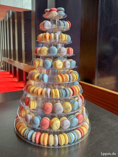 Eine große Etagere mit lauter bunten Macarons, auf die jeweils klein das Gebäude der Oper aufgedruckt ist.