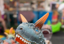Ein Plastik-Dinosaurier brüllt ins Bild